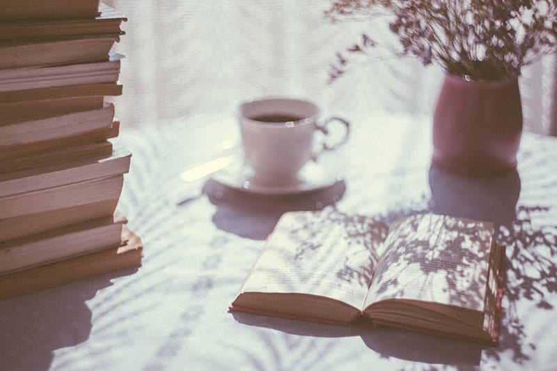 book open next to coffee cup is what you should be reading